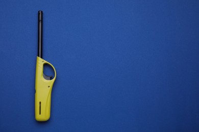 Photo of One gas lighter on blue background, top view. Space for text