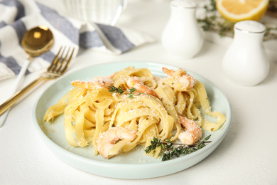 Photo of Delicious pasta with shrimps on white table