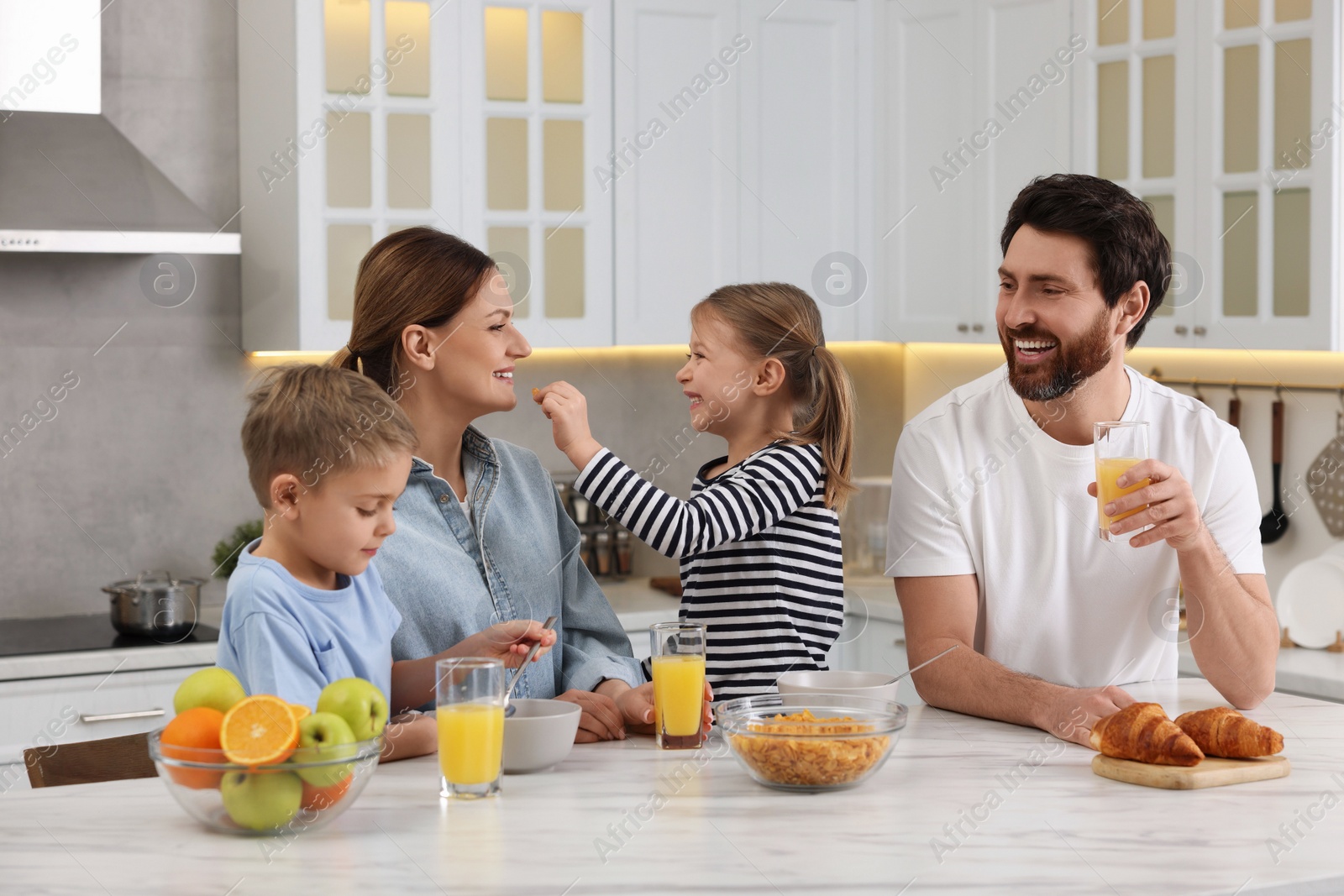 Photo of Happy family having breakfast at table in kitchen