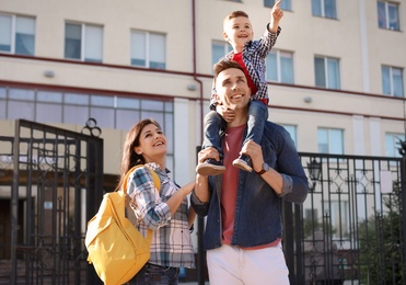 Young parents taking their little child to school