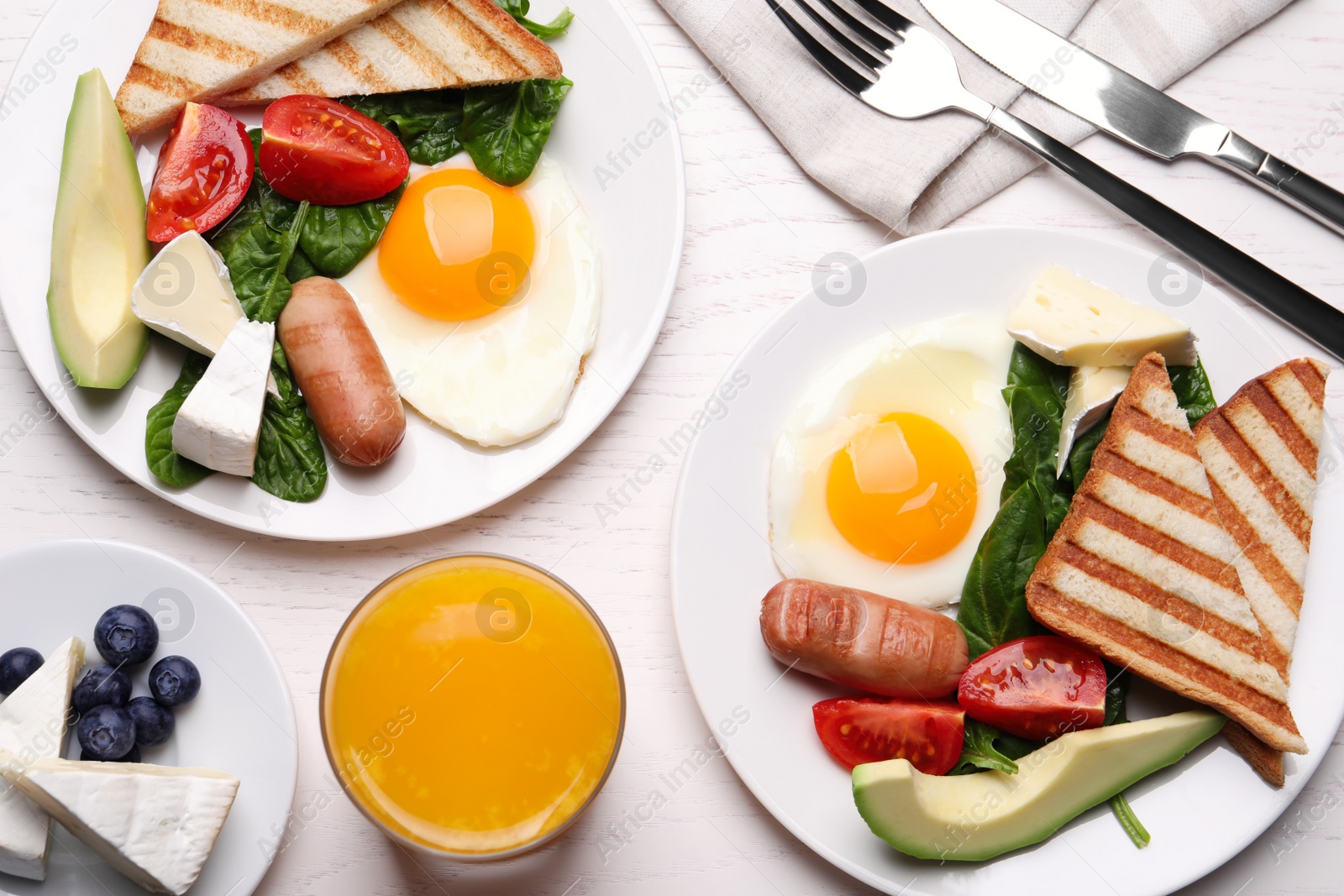 Photo of Delicious breakfast with fried eggs on white wooden table, flat lay