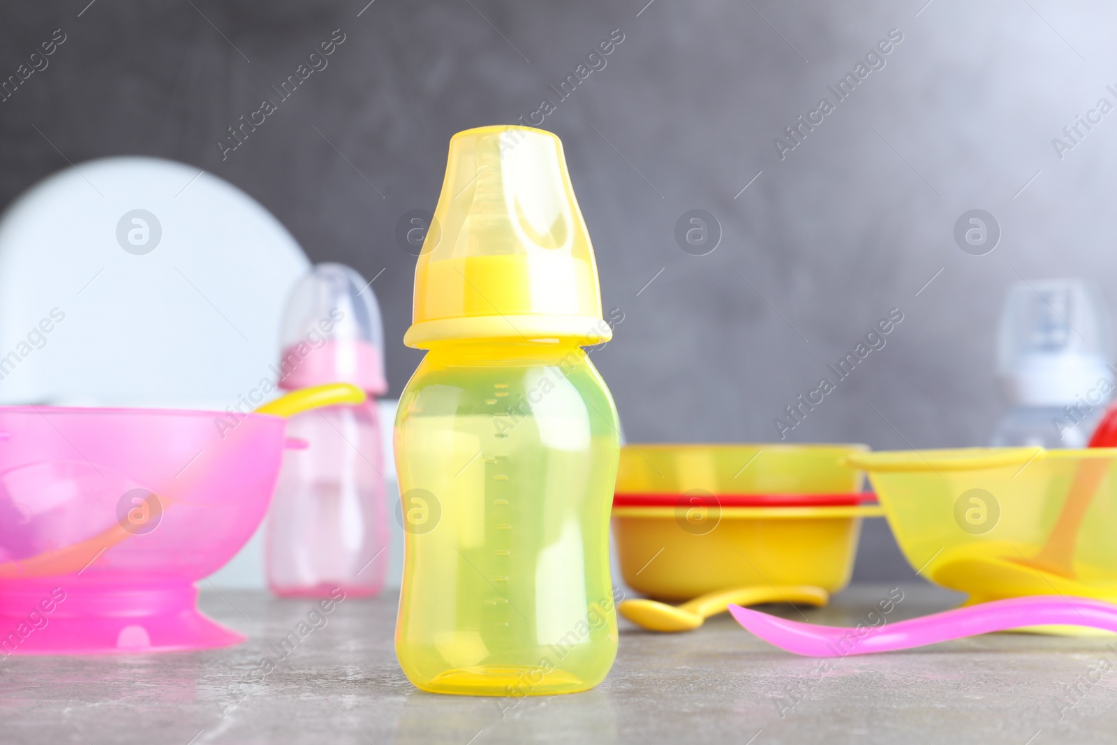 Photo of Bright child's dishware on grey table indoors