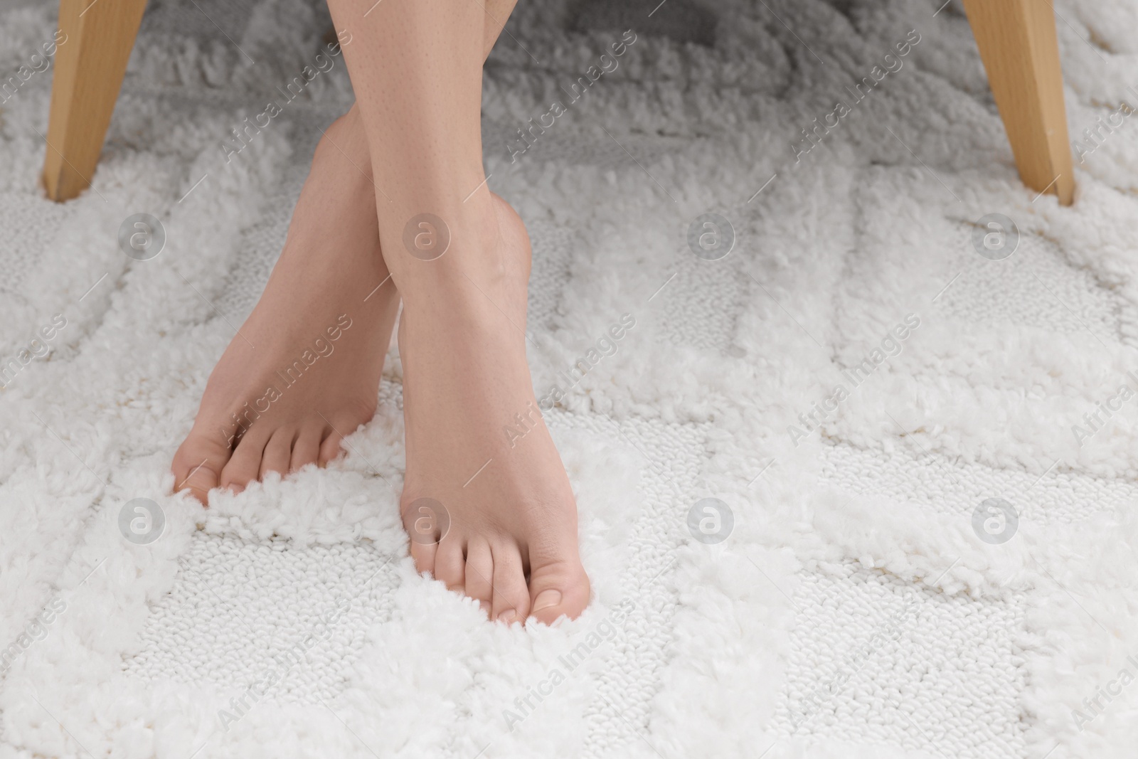 Photo of Woman on soft white carpet at home, closeup. Space for text