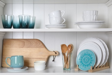 Photo of White shelving unit with set of dishware