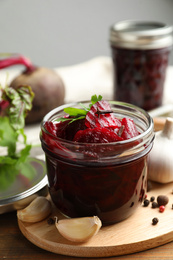 Photo of Delicious pickled beets and spices on wooden table