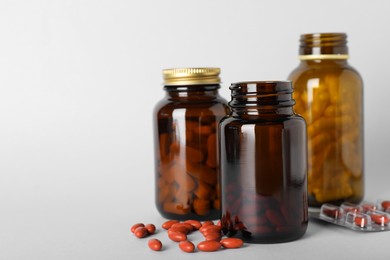 Photo of Bottles pills on light background, space for text. Anemia treatment