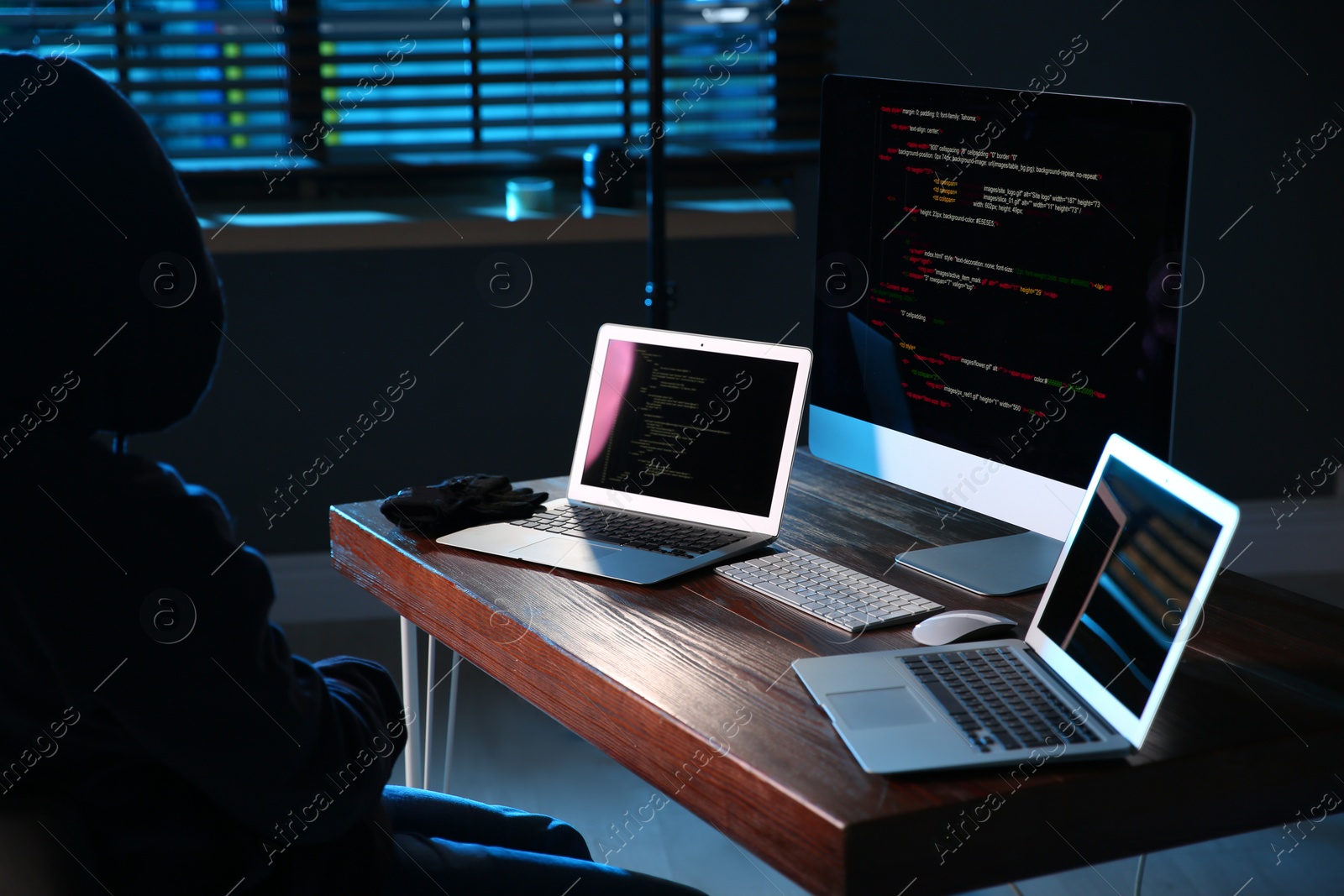 Photo of Hacker with computers in dark room. Cyber crime