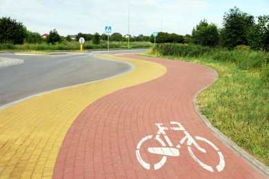 Red bicycle lane on pavement along road