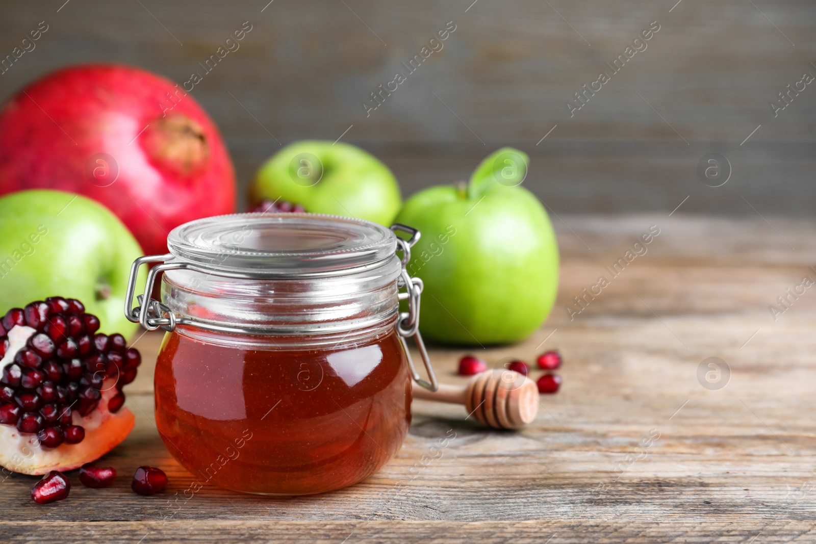 Photo of Honey, pomegranate and apples on wooden table. Rosh Hashana holiday