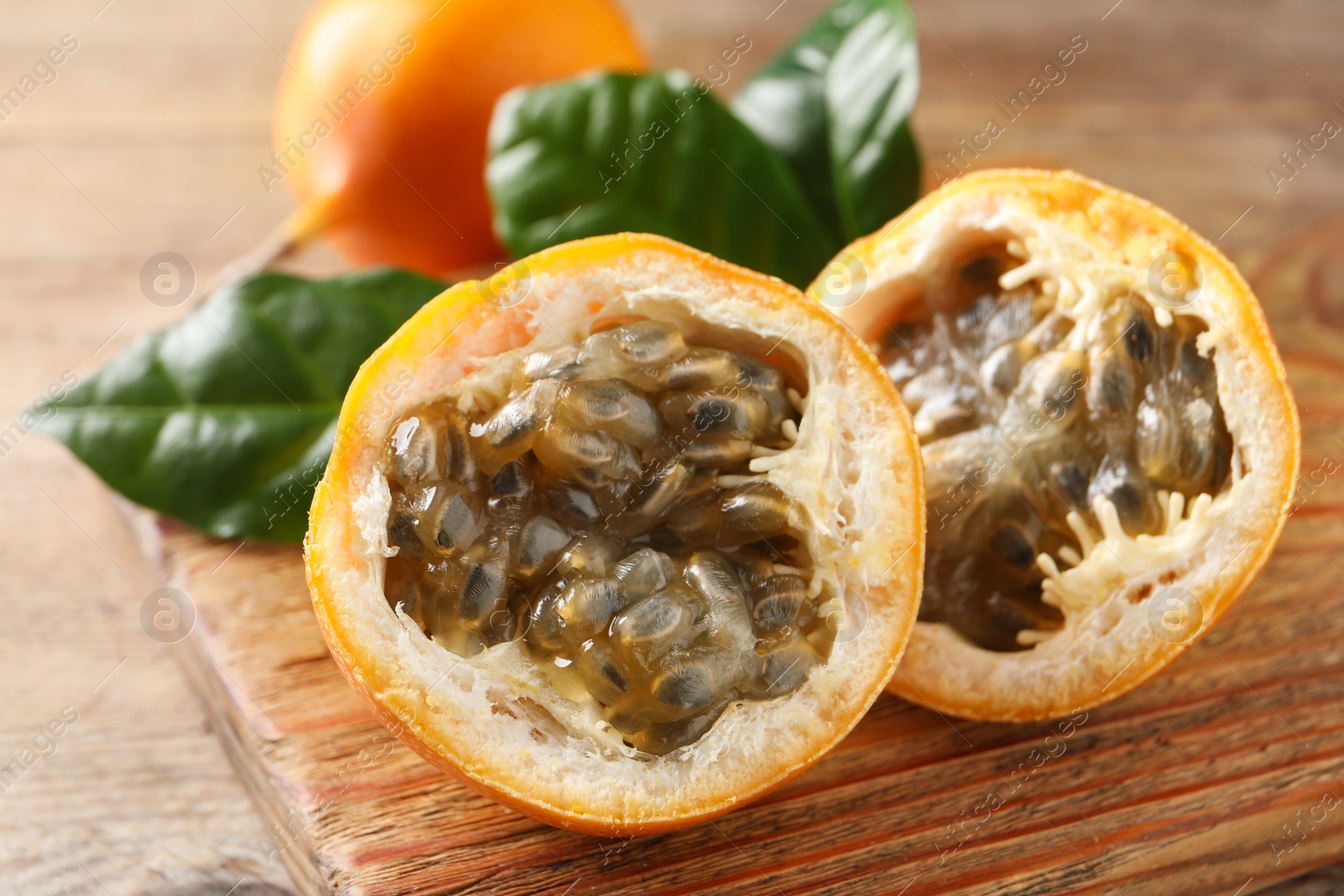 Photo of Delicious ripe granadillas on wooden table, closeup