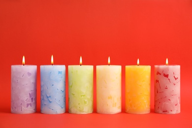 Photo of Alight scented wax candles on color background