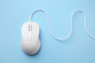 Photo of One wired mouse on light blue background, top view