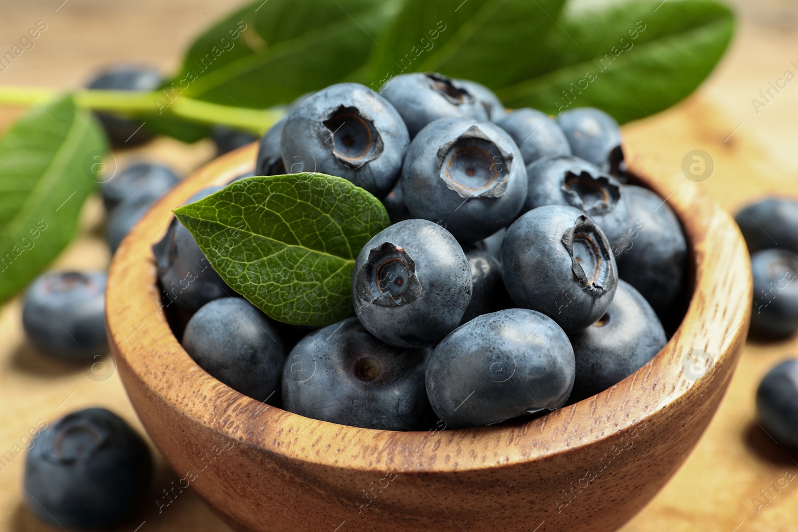 Photo of Bowl of fresh tasty blueberries on table, closeup