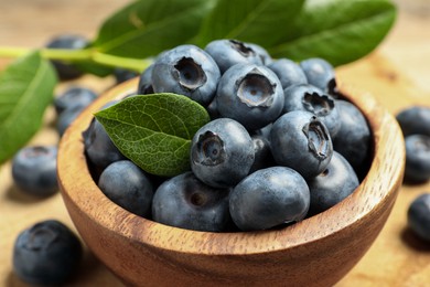 Photo of Bowl of fresh tasty blueberries on table, closeup
