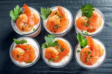 Photo of Glasses with fried shrimps and sauce on wooden background