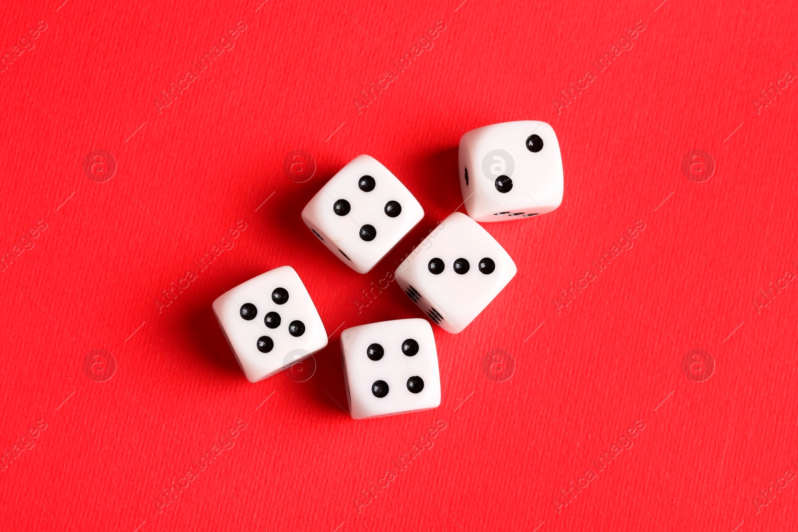 Photo of Many white game dices on red background, flat lay