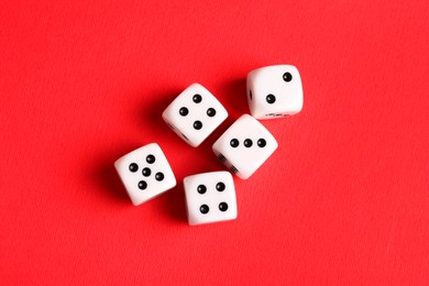 Photo of Many white game dices on red background, flat lay