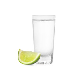 Photo of Shot of vodka with lime slice on white background
