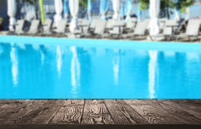 Wooden deck near swimming pool outdoors on sunny day. Space for text