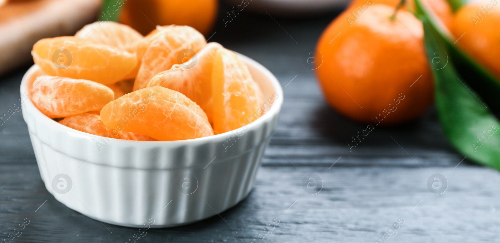 Photo of Fresh tangerine slices on grey wooden table, closeup. Space for text