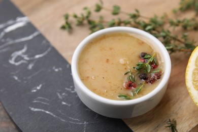 Photo of Delicious turkey gravy, thyme and peppercorns on board, closeup. Space for text