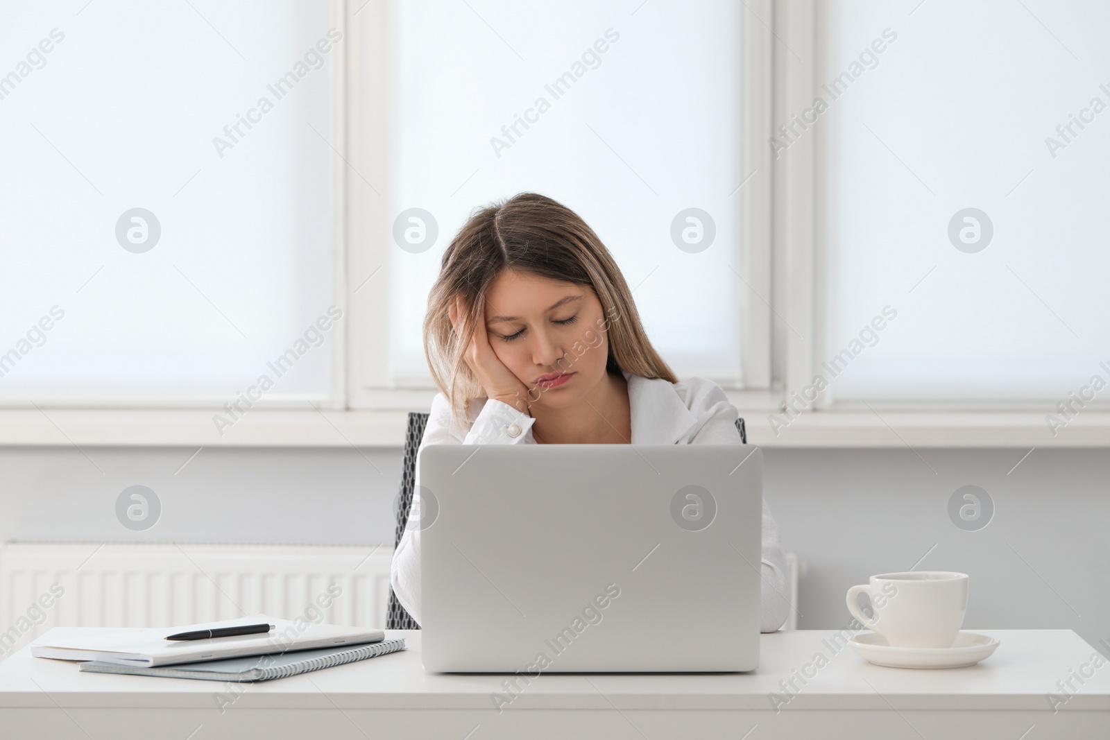 Photo of Tired young woman sleeping at workplace in office