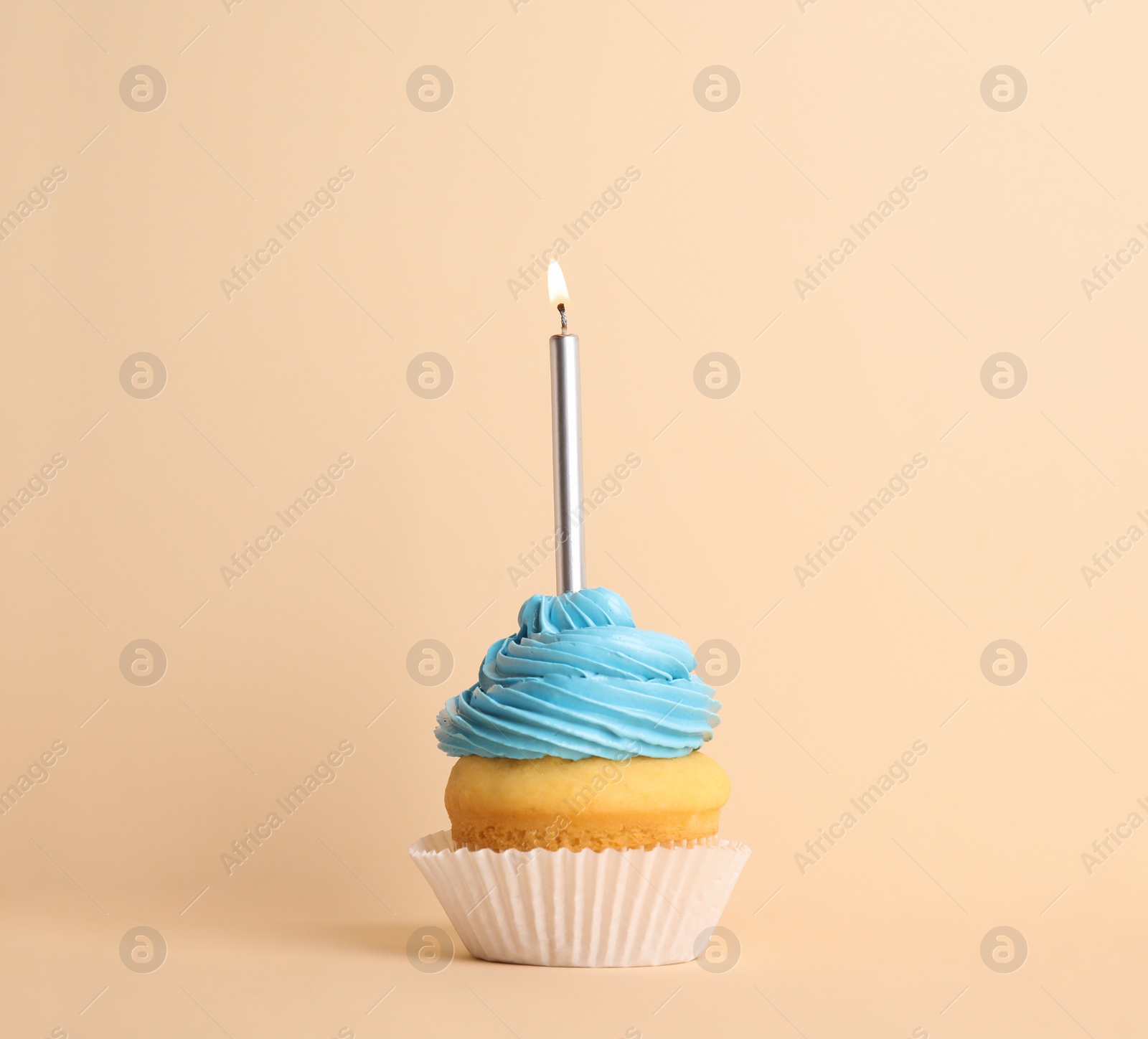 Photo of Birthday cupcake with candle on beige background