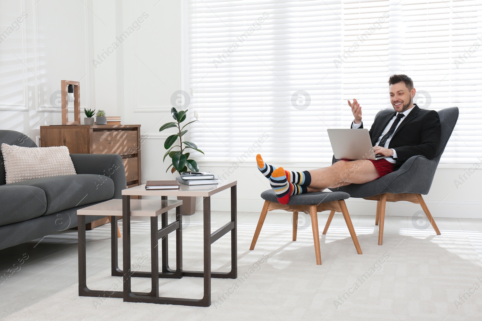 Photo of Businessman in underwear pretending to wear formal clothes during video call at home