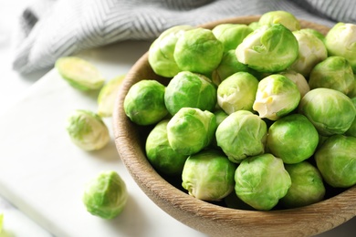 Photo of Bowl with fresh Brussels sprouts on table, closeup. Space for text