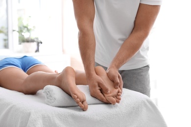 Photo of Young woman receiving massage in salon, closeup