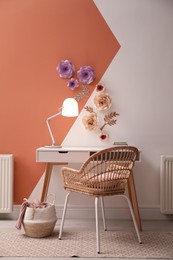Photo of Workplace near color wall with floral decor indoors