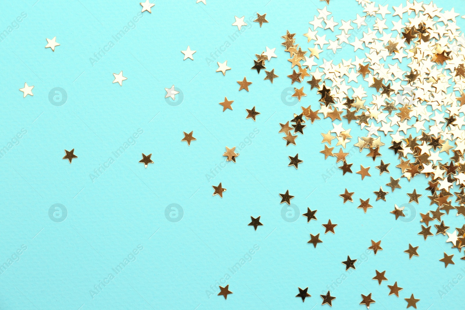 Photo of Confetti stars on light blue background, flat lay. Christmas celebration