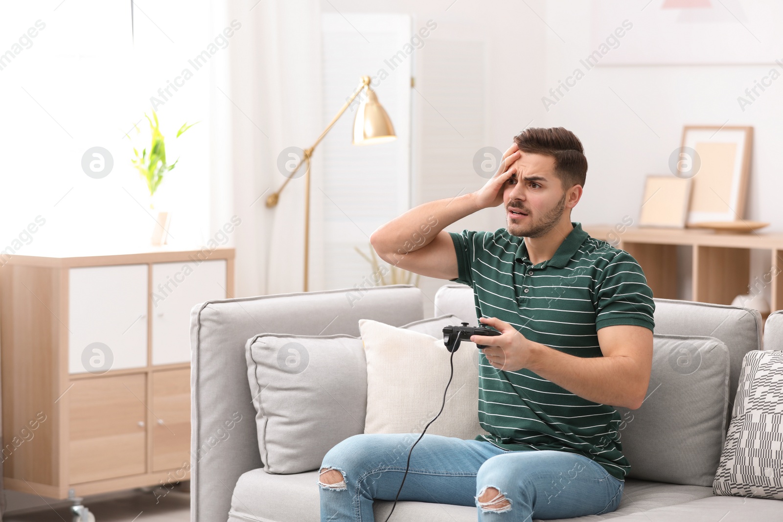 Photo of Emotional young man playing video games at home