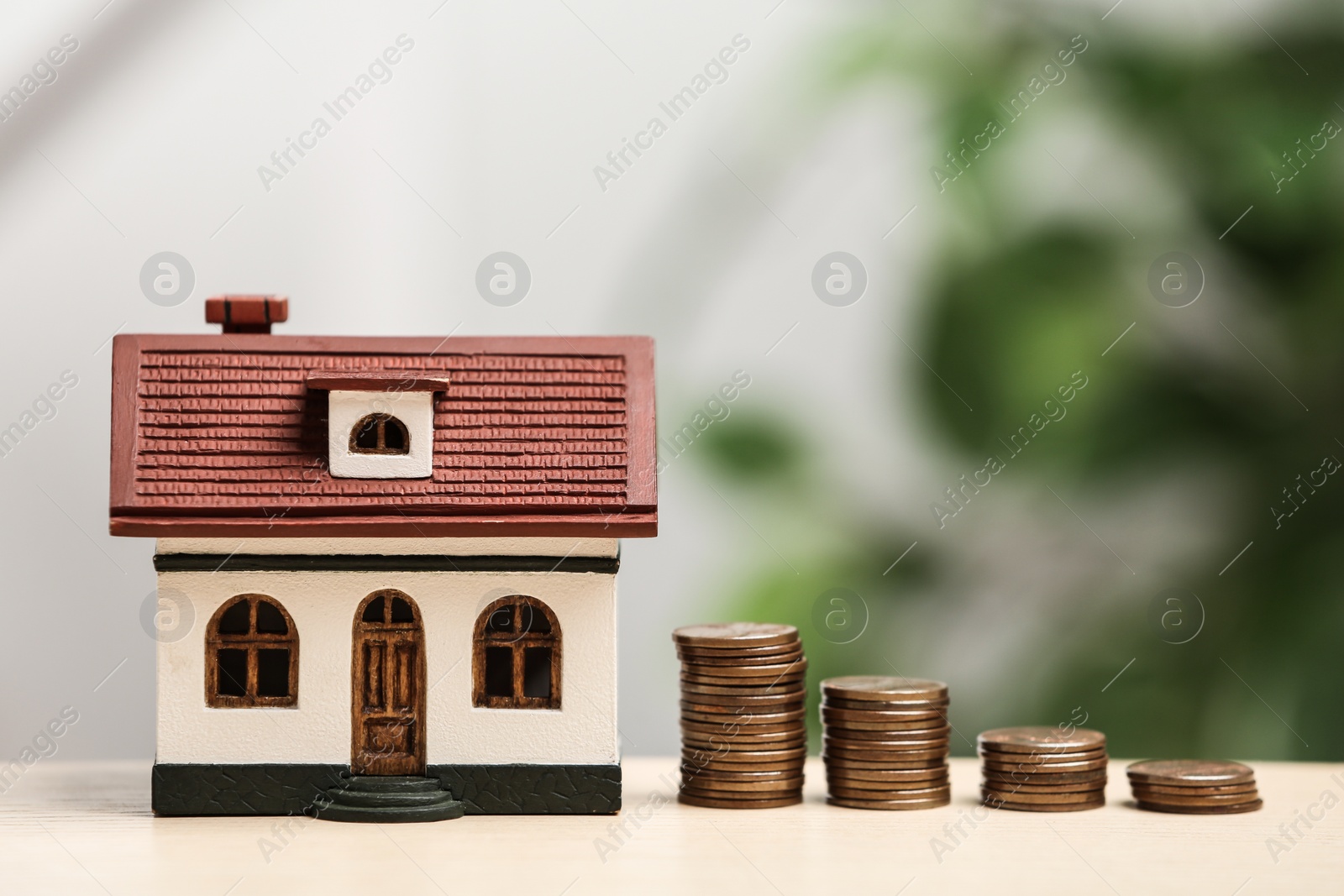 Photo of House model and coins on table. Money savings