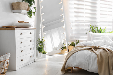 Photo of White chest of drawers in beautiful bedroom. Interior design