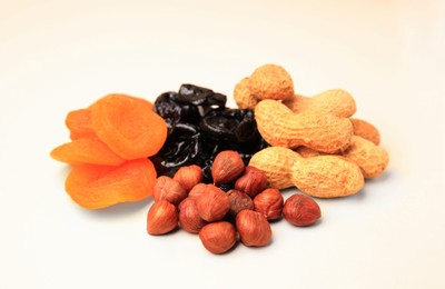 Photo of Pile of dried fruits and nuts on white background, closeup