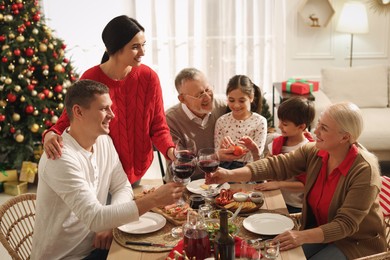 Photo of Happy family enjoying festive dinner at home. Christmas celebration