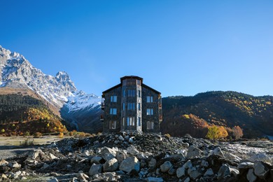 Photo of Picturesque view of high mountains and stone building on sunny day