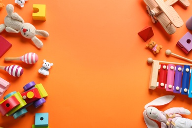 Photo of Flat lay composition with different toys on orange background. Space for text