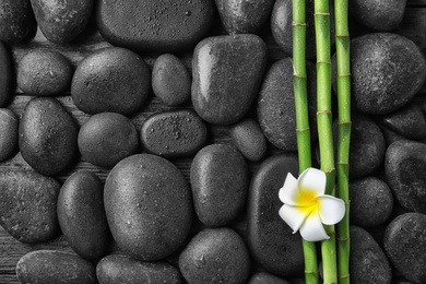 Photo of Flat lay composition with bamboo branches and spa stones as background. Space for text