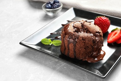 Photo of Plate of delicious fresh fondant with hot chocolate and strawberries on table. Lava cake recipe