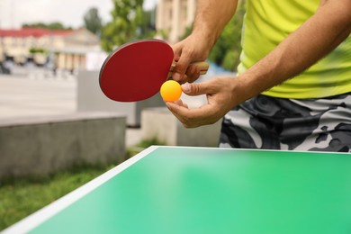 Photo of Man playing ping pong outdoors on summer day, closeup