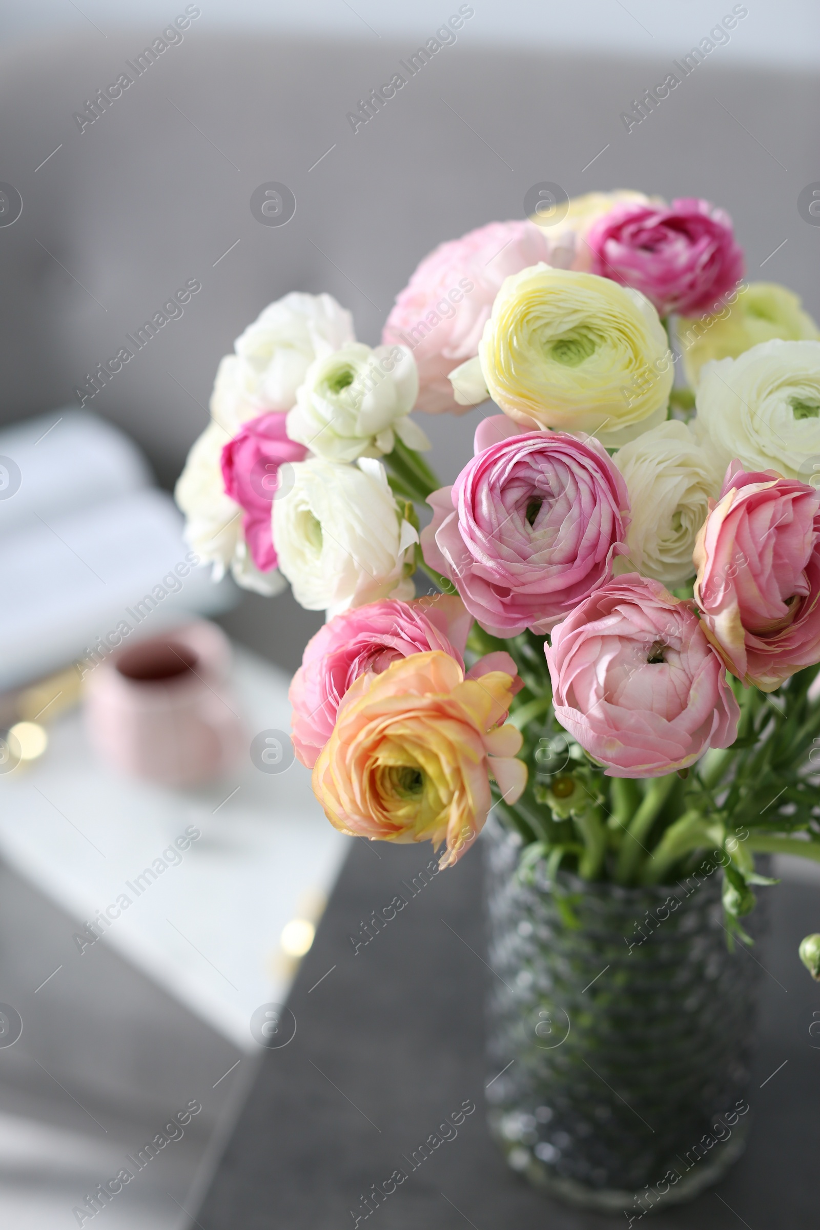 Photo of Bouquet of beautiful ranunculuses on table in living room