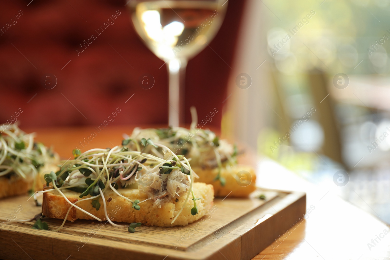 Photo of Delicious bruschettas with fish on table in cafe