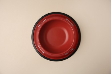 Photo of Empty red feeding bowl on beige background, top view