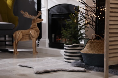 Photo of Beautiful room interior with potted fir tree and fireplace