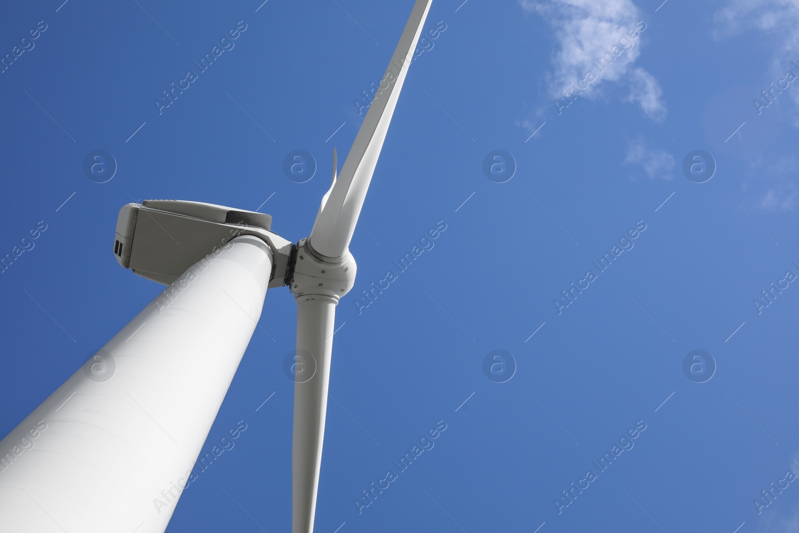 Photo of Wind turbine against beautiful blue sky, low angle view. Alternative energy source