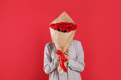 Photo of Woman with tulip bouquet on red background. 8th of March celebration