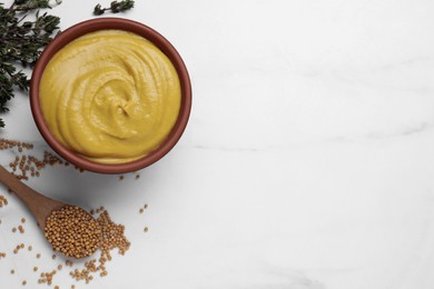 Photo of Bowl with delicious mustard, seeds and dry thyme on white marble table, flat lay. Space for text