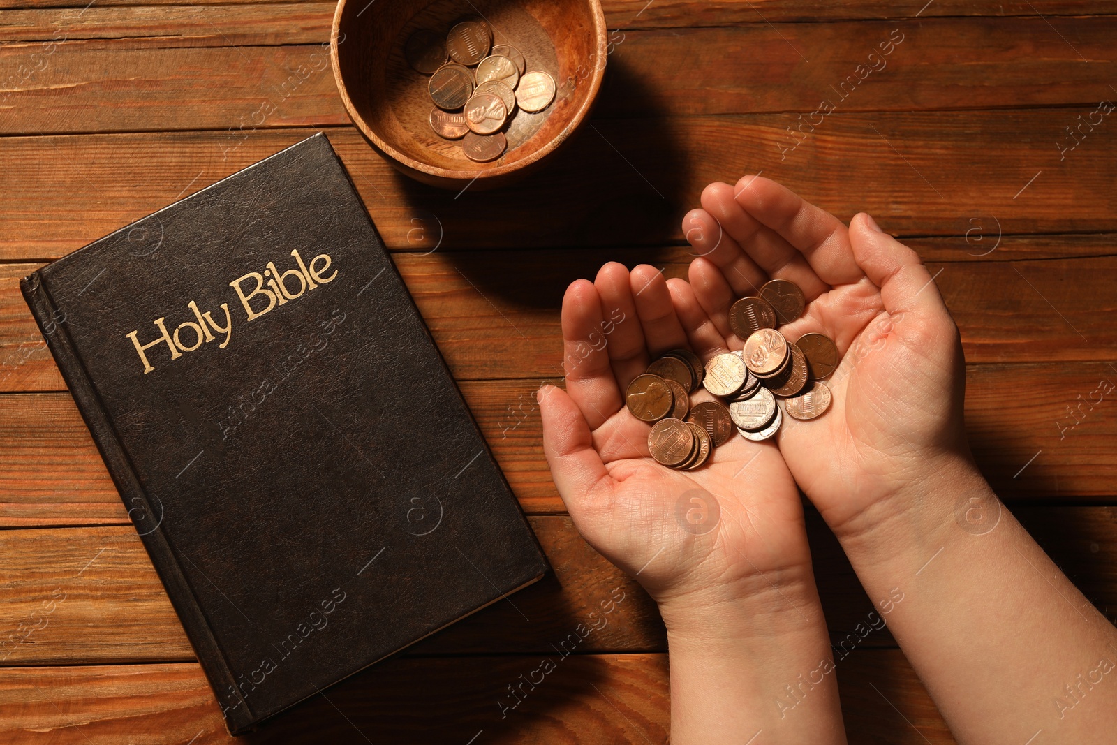 Photo of Donate and give concept. Woman with money, closeup. Bible and bowl of coins on wooden table, top view